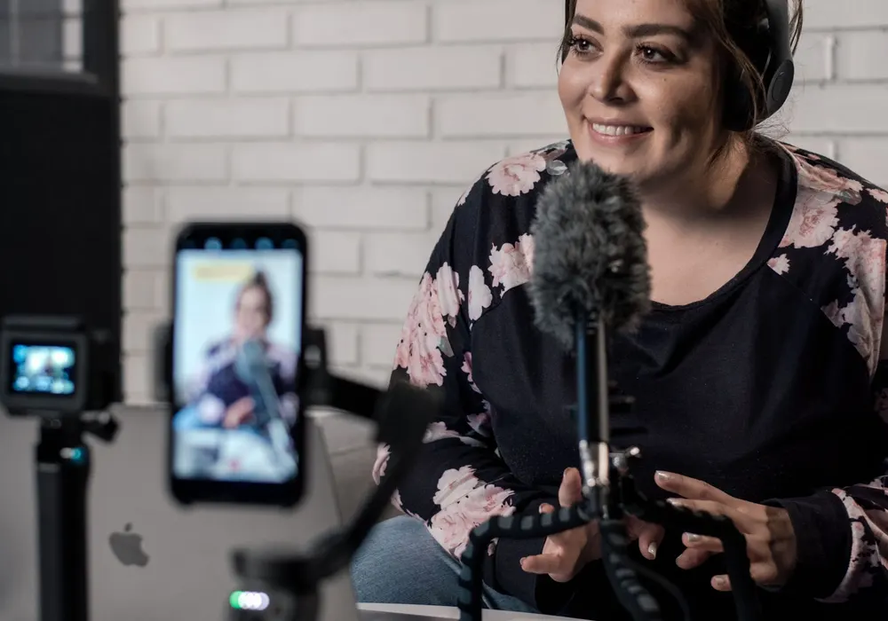 Content creator recording a video with a microphone and a phone on a stand