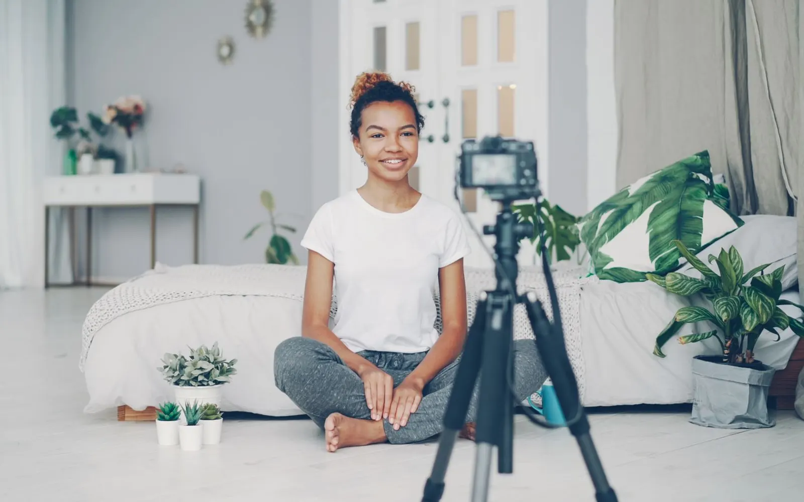 Content creator recording a video at home with a camera on a tripod